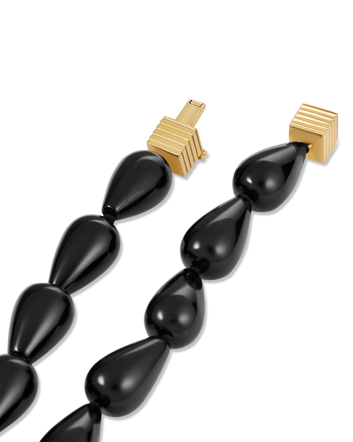 Black teardrop-shaped beaded necklace with gold clasp on a white background