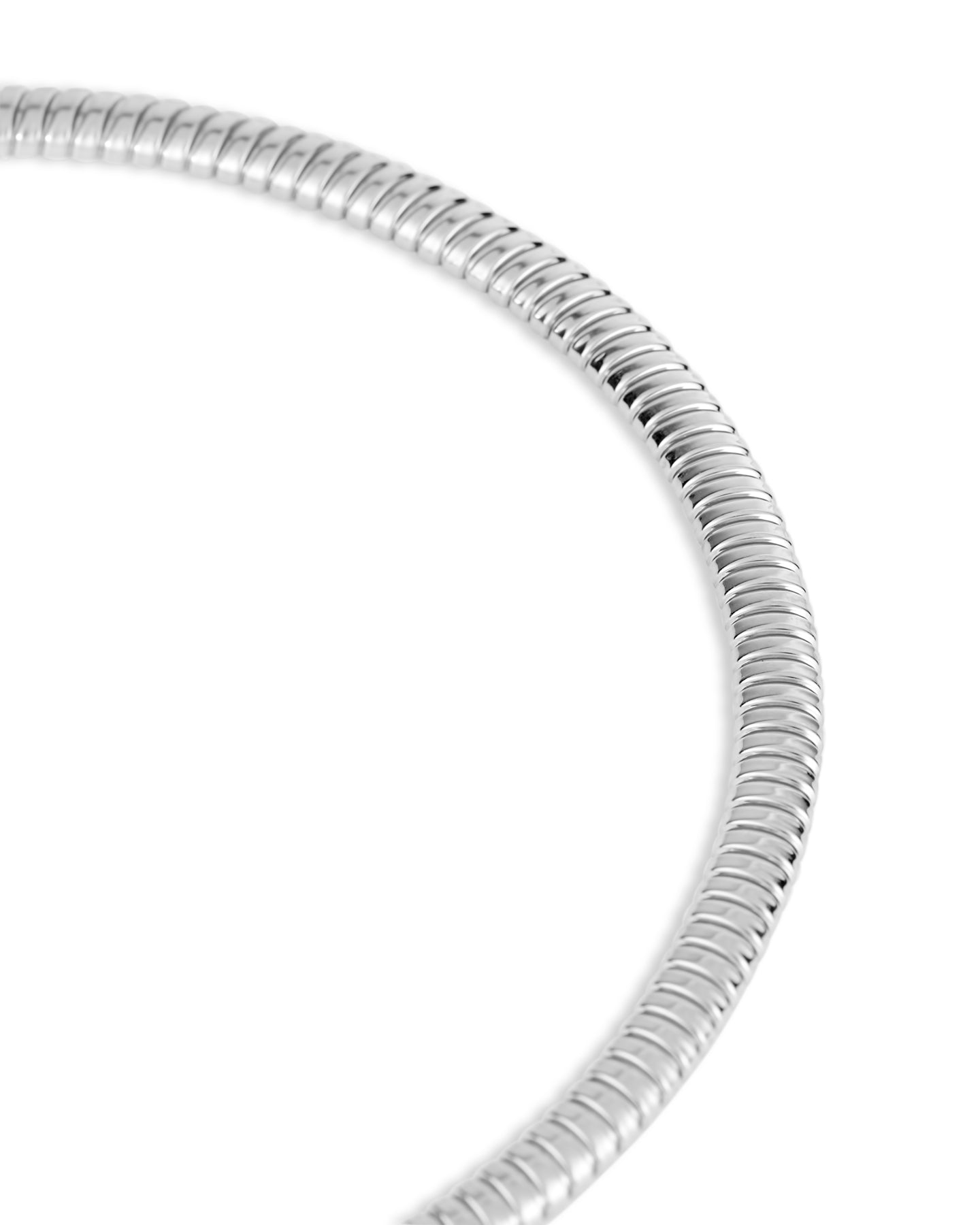A close up of a rhodium-plated tubogas necklace with a flexible ribbed design and concealed clasp on a white background.
