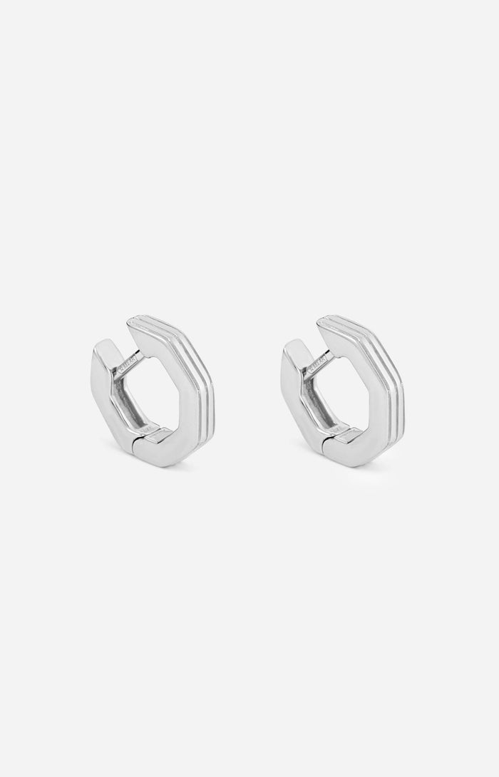 A pair of rhodium-plated octagon-shaped huggies earrings on a white background