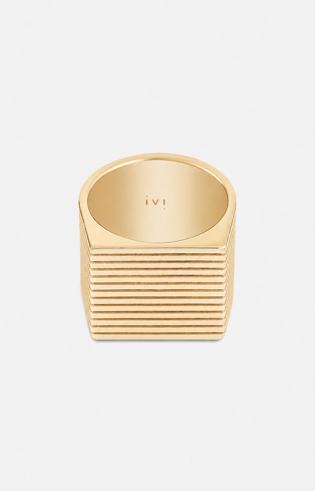 Gold ring with ribbed design on a light gray background