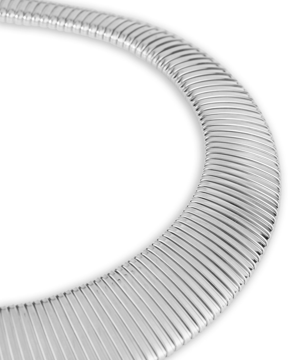 A close up of a silver silver-colored necklace with a chunky, flexible design. 