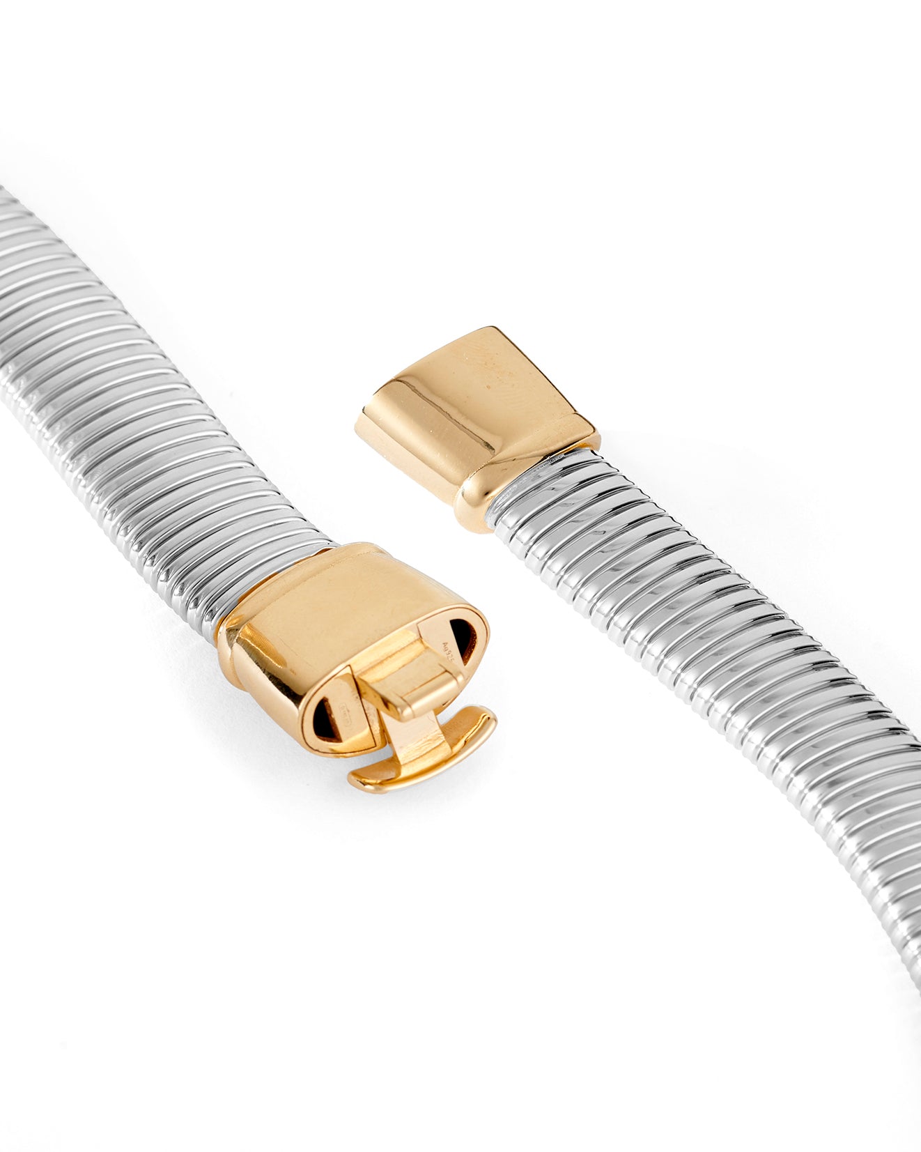 A close up of a silver-colored necklace with a chunky, flexible design and a gold-plated clasp. 