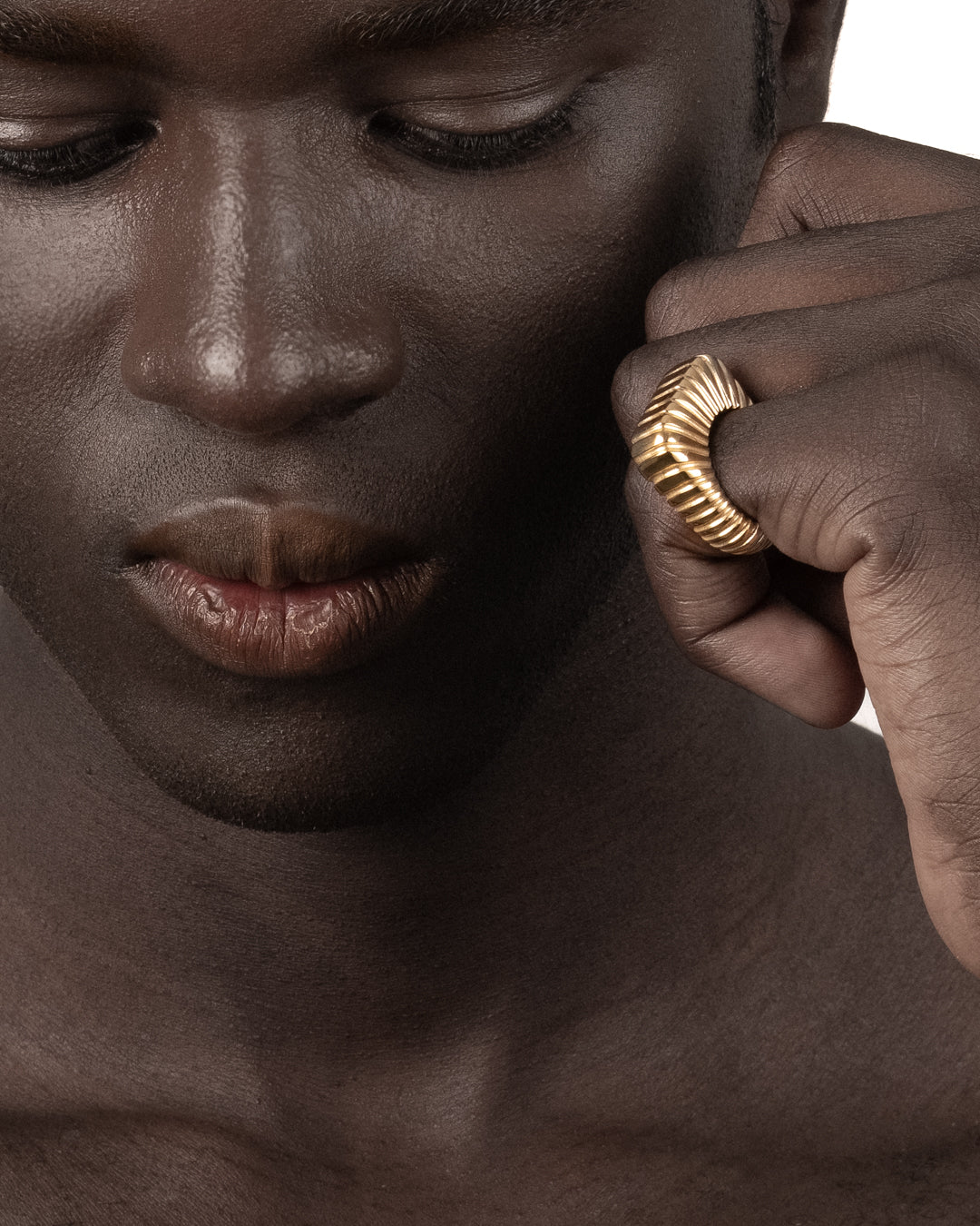 Bold gold ridged statement ring worn on a hand, shown in a lifestyle close-up.