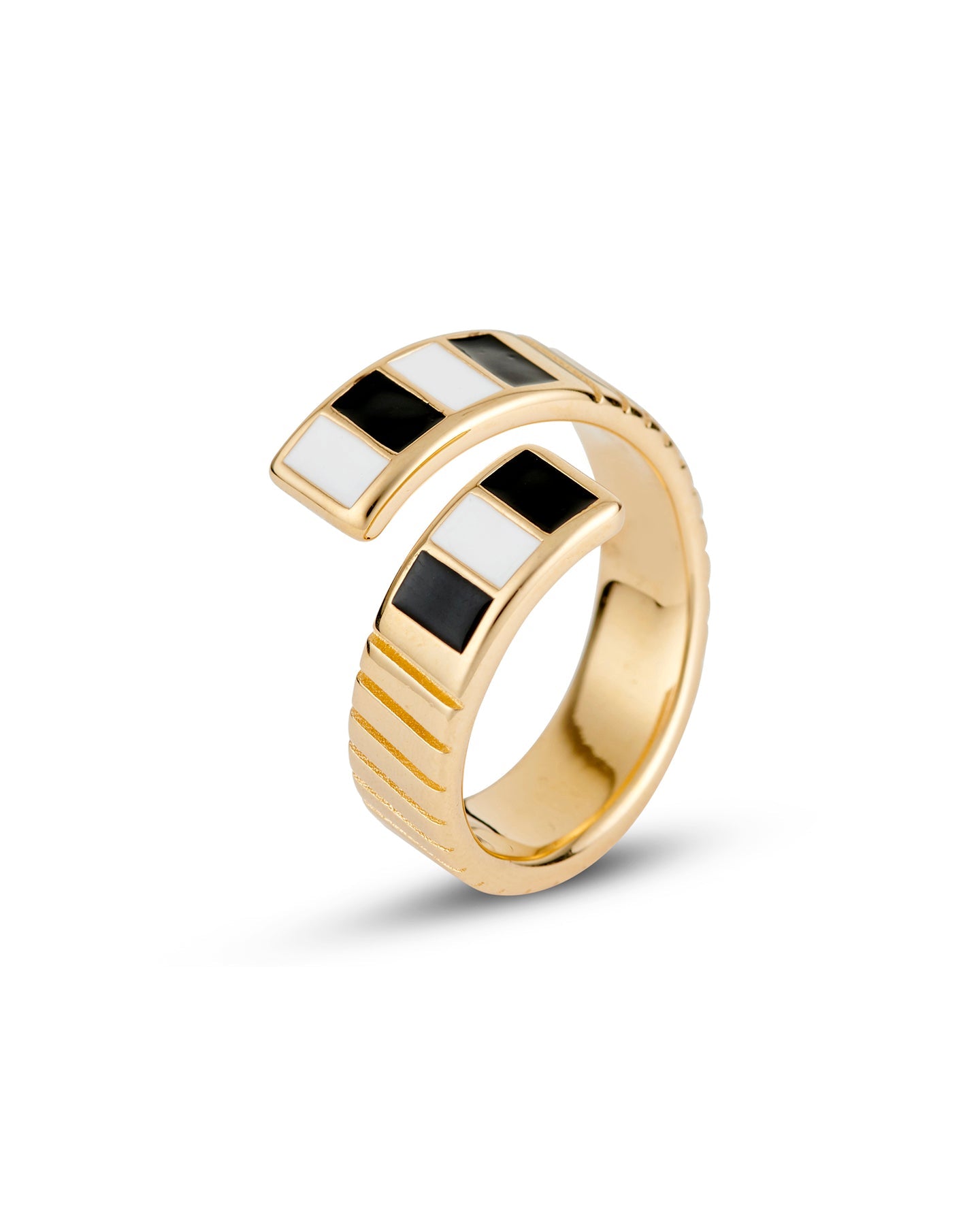 A gold-plated twist ring with polished black and white enamel stripes at the tips, with a textured surface and signature linear engravings.