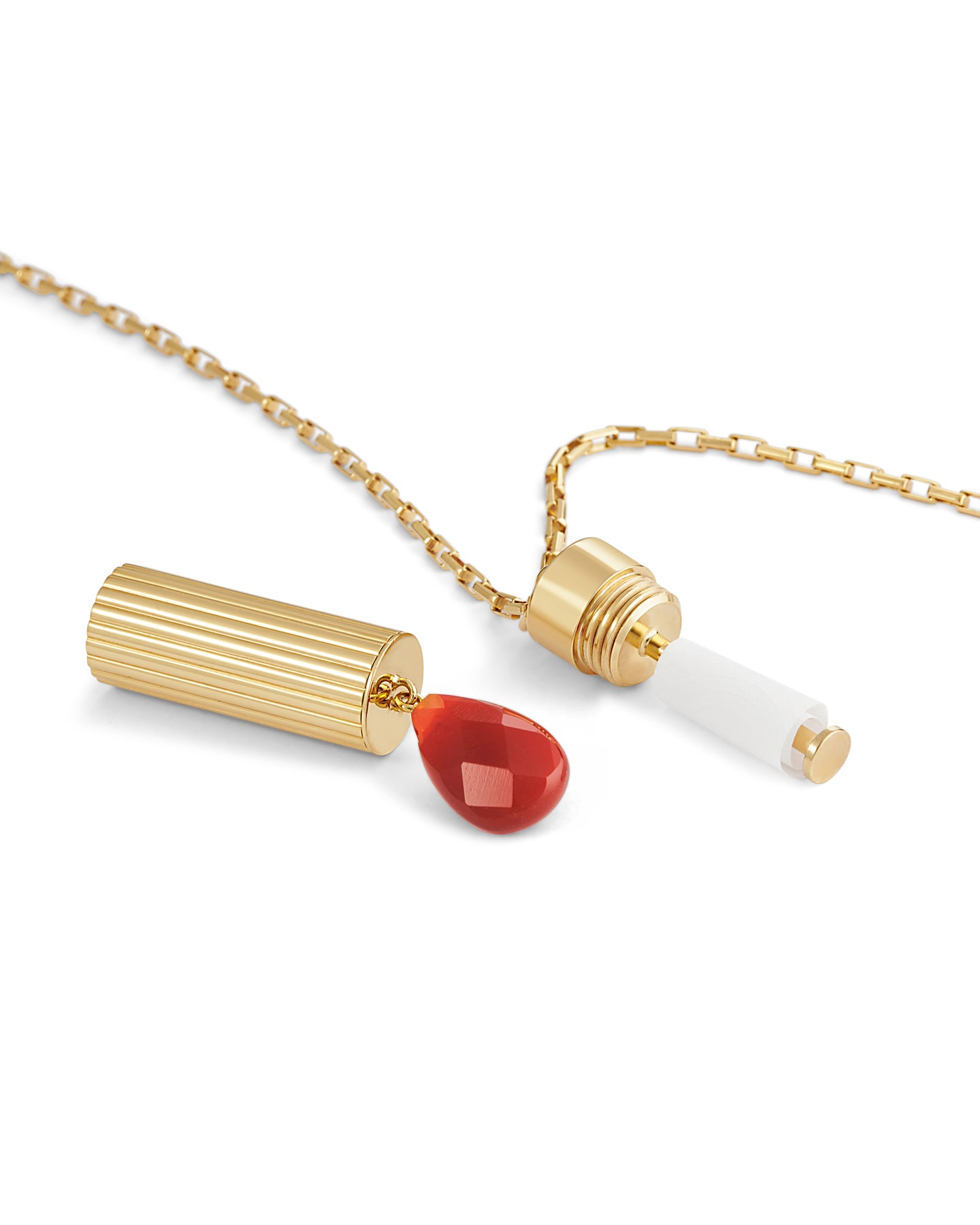 Gold necklace with a red pendant on a white background