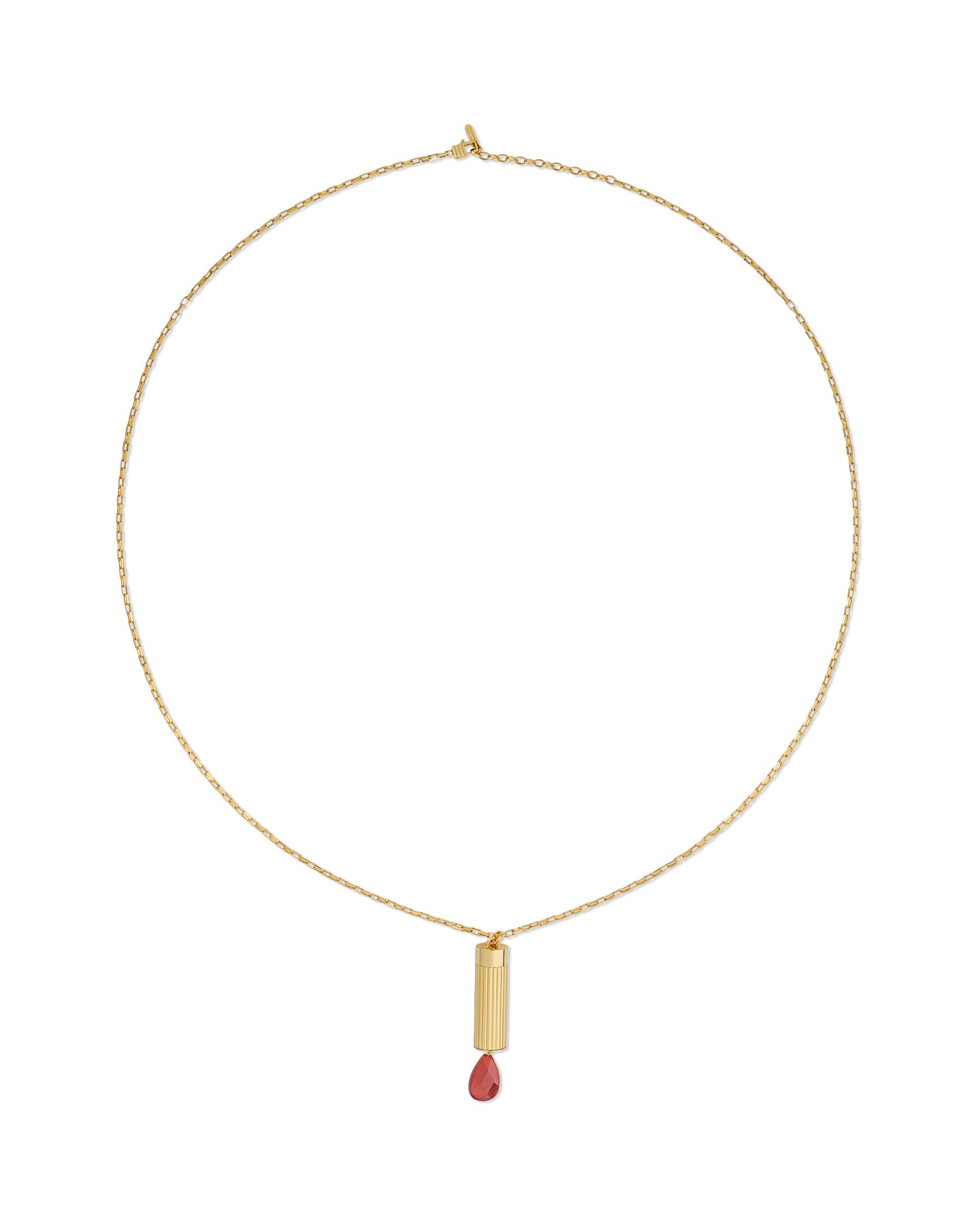 Gold necklace with a cylindrical pendant and red gemstone on a white background