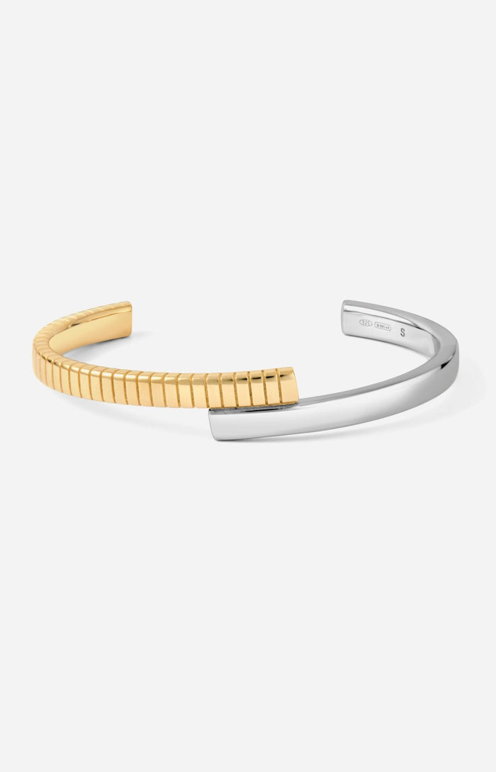 A two-tone (gold and silver) twist cuff bracelet with a mixed-metal finish.
