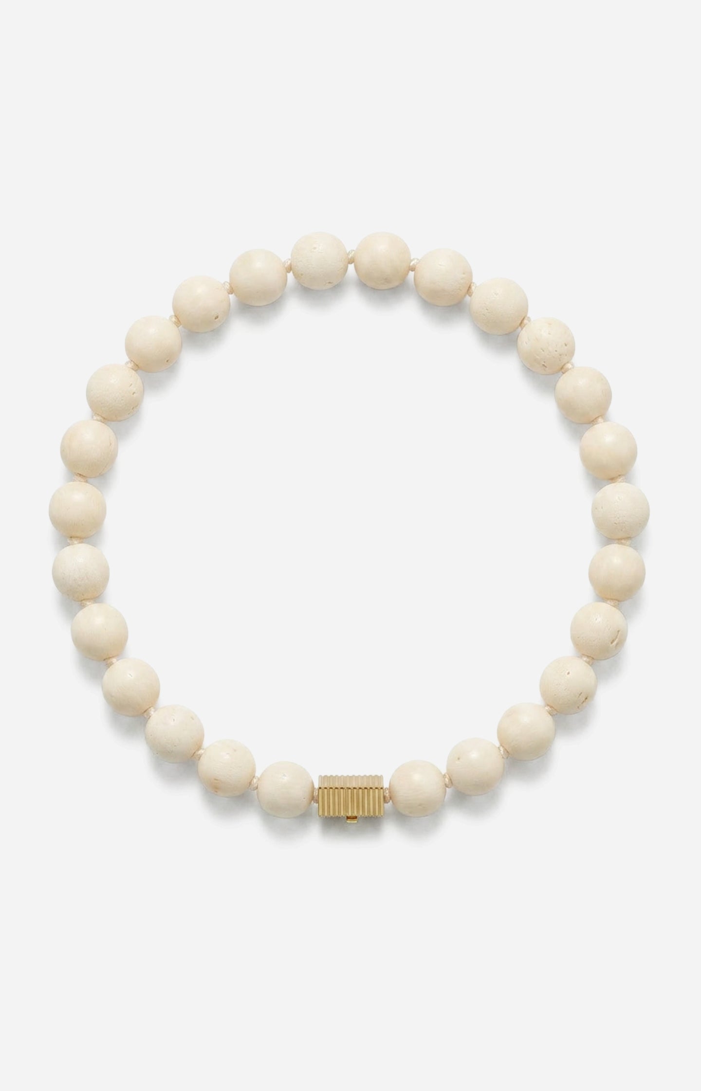 White beaded bracelet with a gold clasp on a white background