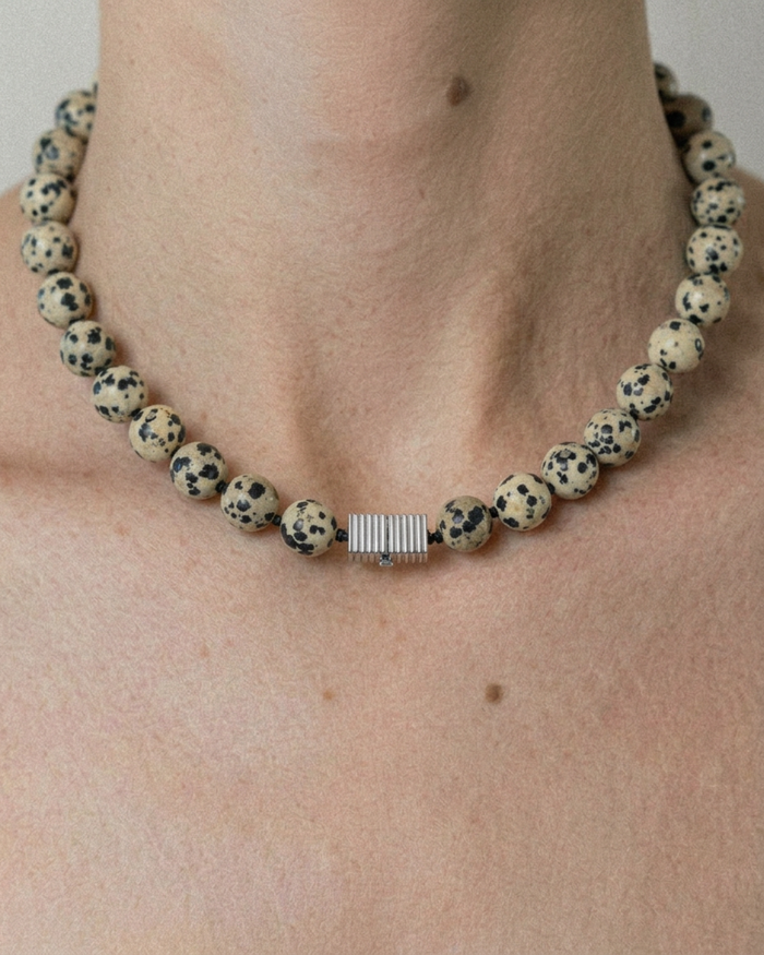 Necklace with dalmatian jasper beads on a person's neck