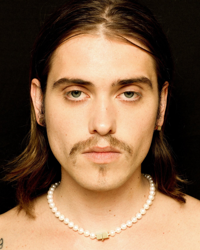 Pearl necklace with a gold clasp worn by a model. 