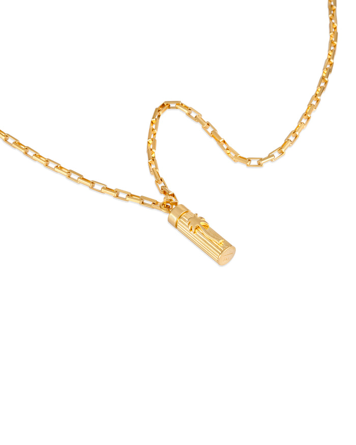 Gold necklace with a cylindrical pendant featuring a palm tree motif on a white background.