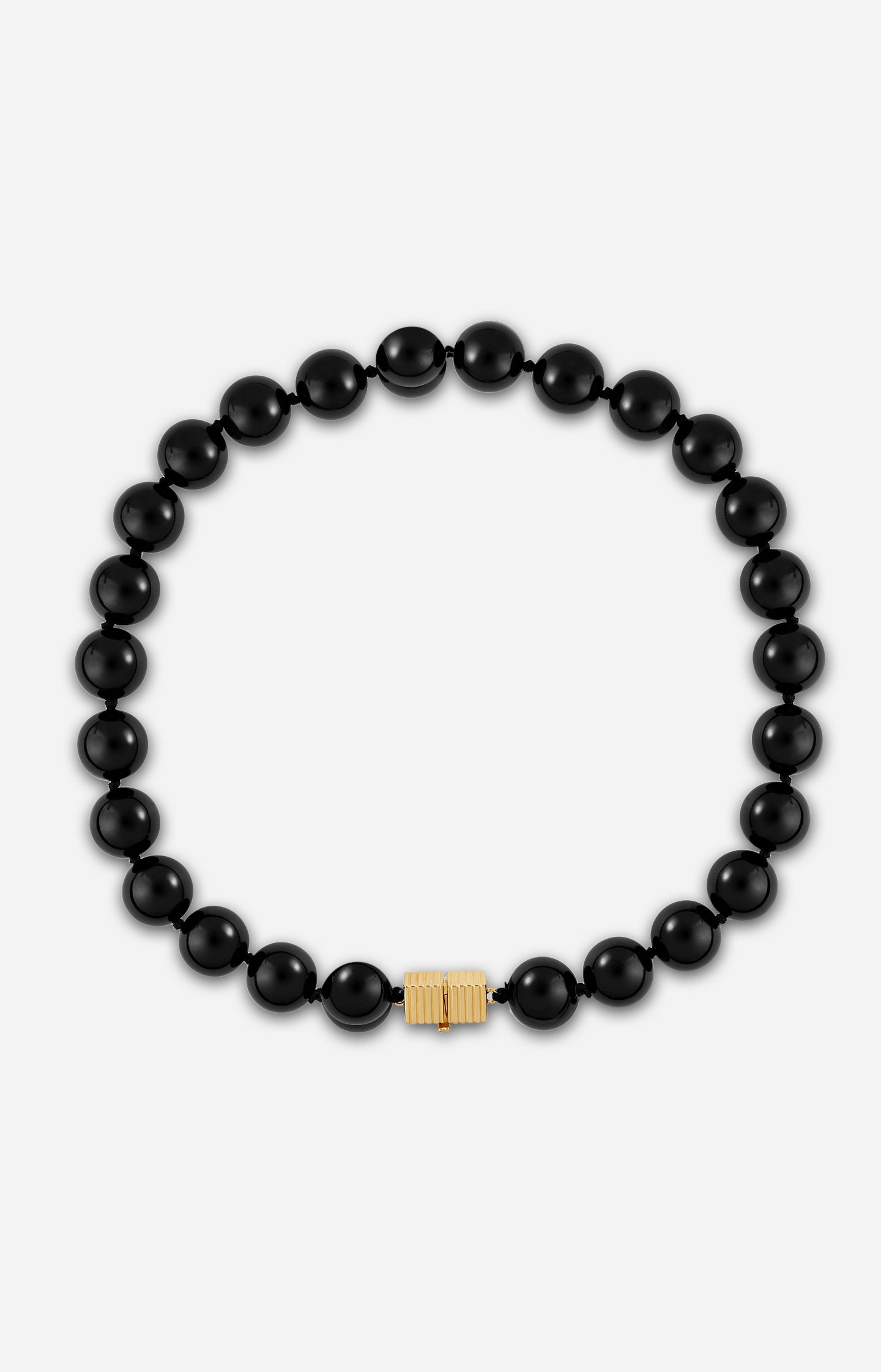 An onyx black beaded necklace with gold-plated clasp on a white background.