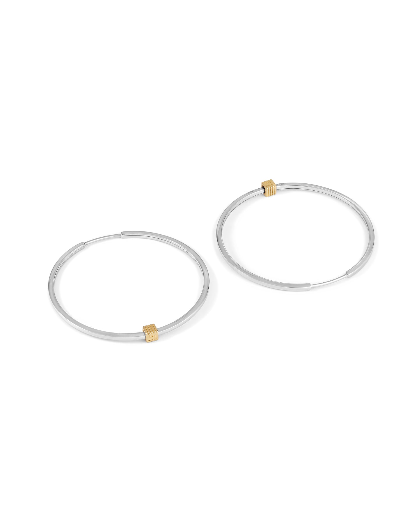 A pair of rhodium-plated medium-sized hoop earrings with a single engraved cube detail on one side.