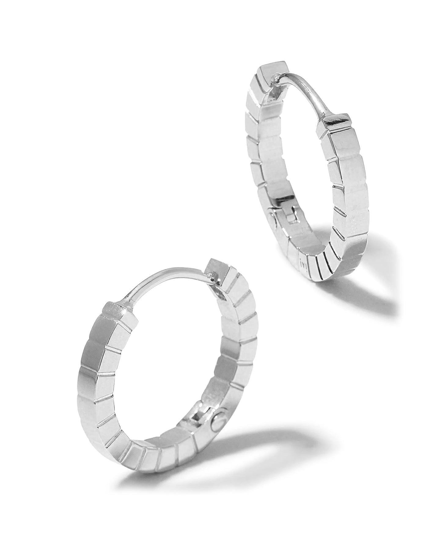 A pair of medium rhodium-plated Signore hoop earrings with a textured design, resembling a curving row of square beads.