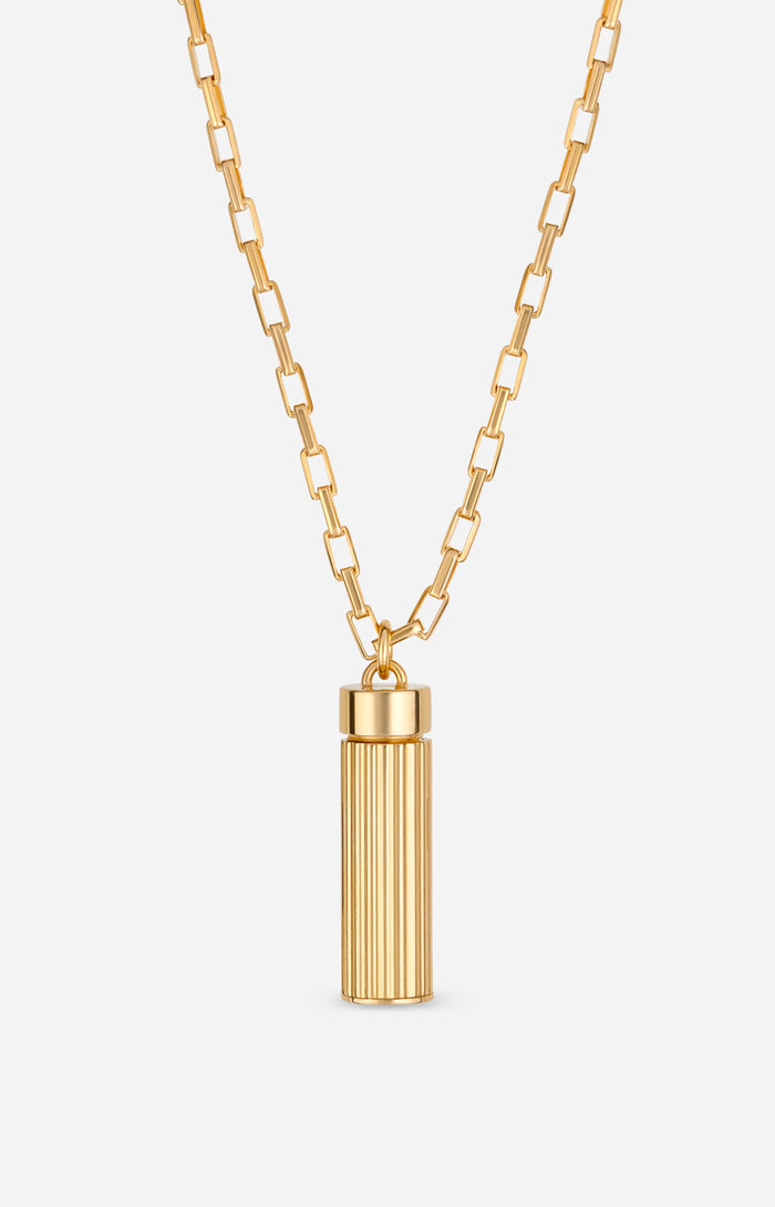 Gold necklace with a cylindrical pendant on a white background