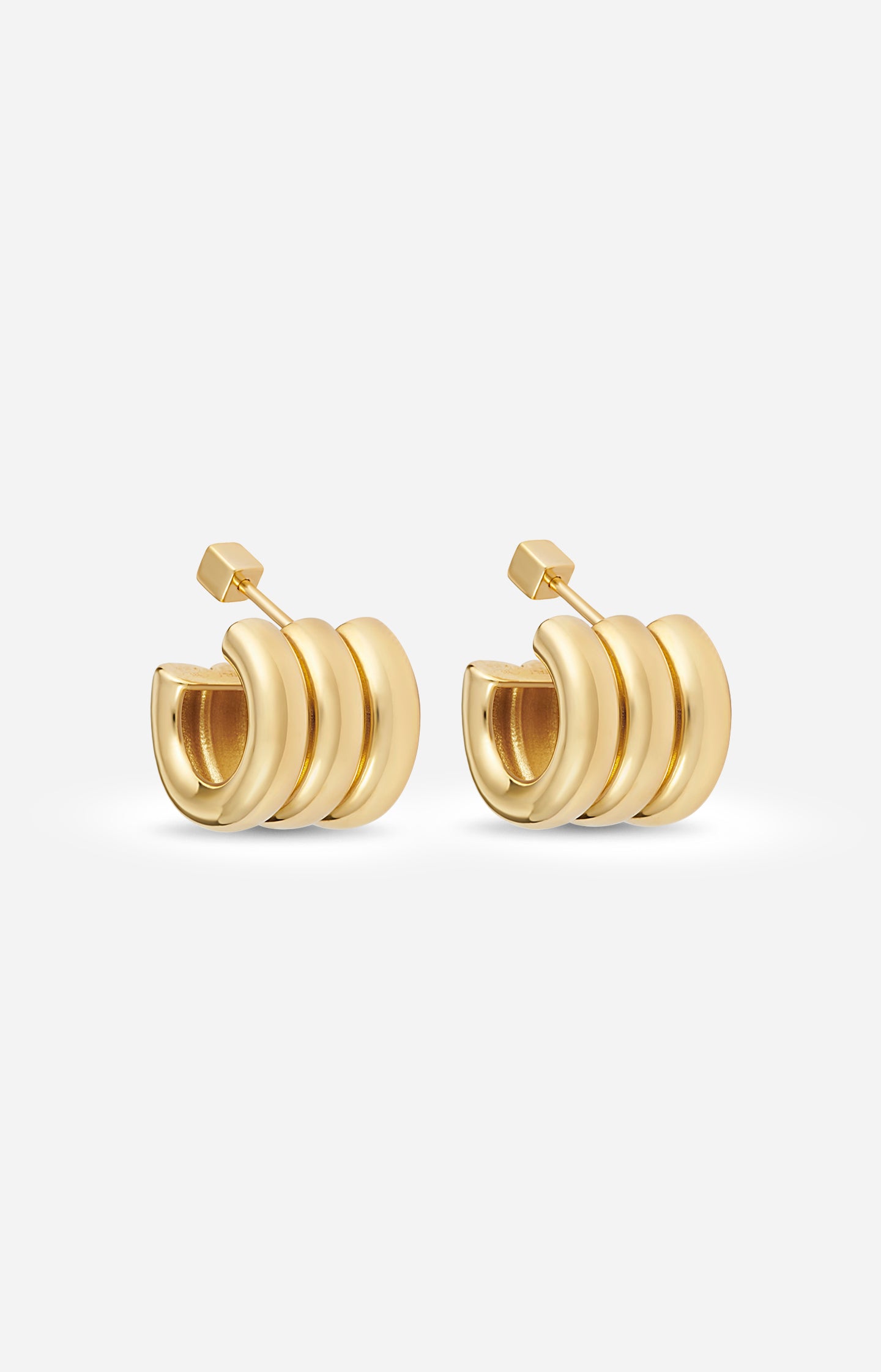 Pair of gold-plated Mini Gaia sculptural hoop earrings on a white background. 