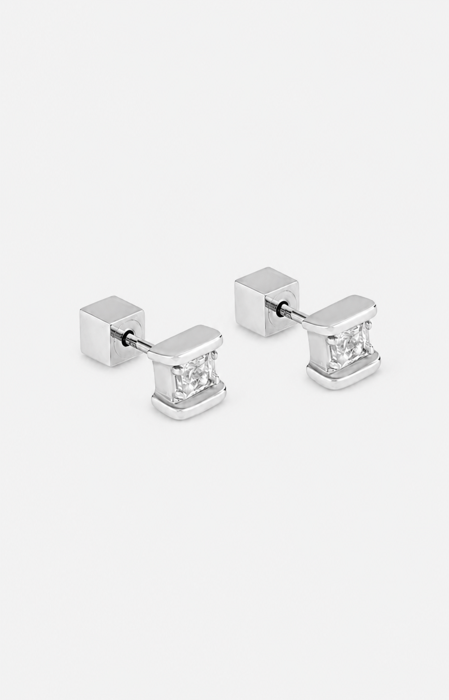 Pair of silver square stud earrings with clear gemstones on a white background