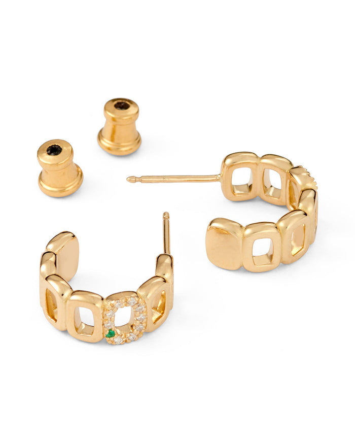 A pair of mini toy hoop earrings crafted from 18-karat gold, featuring oval links adorned with diamonds and an emerald.