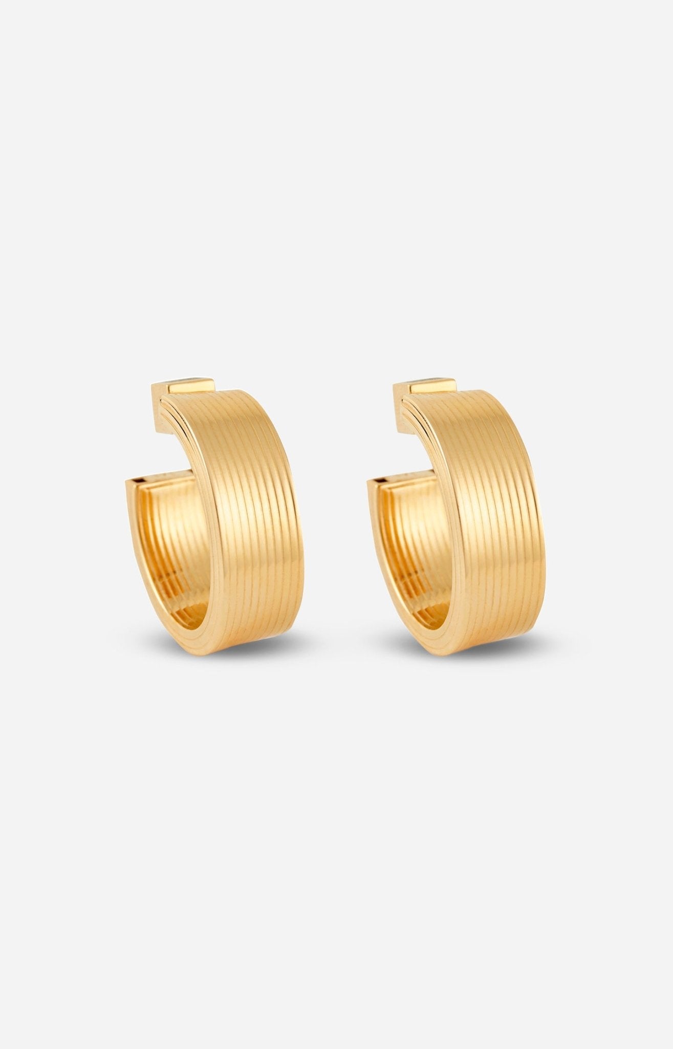 A pair of gold-plated hollow hoop earrings with a square post, displayed on a white background.