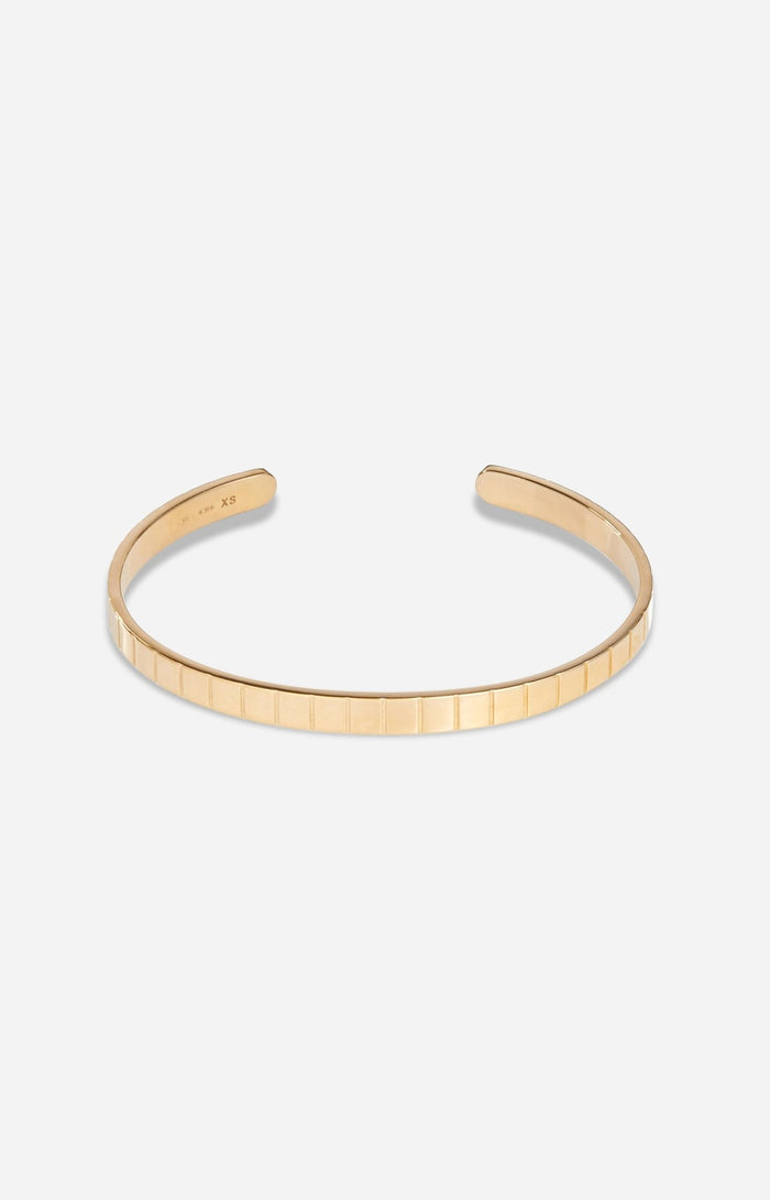 A gold-plated single slot cuff bracelet with a grooved profile on a white background.