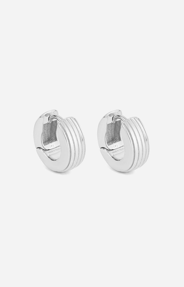 A pair of rhodium-plated round huggies earrings with a slim curved silhouette and engraved detailing on a white background.