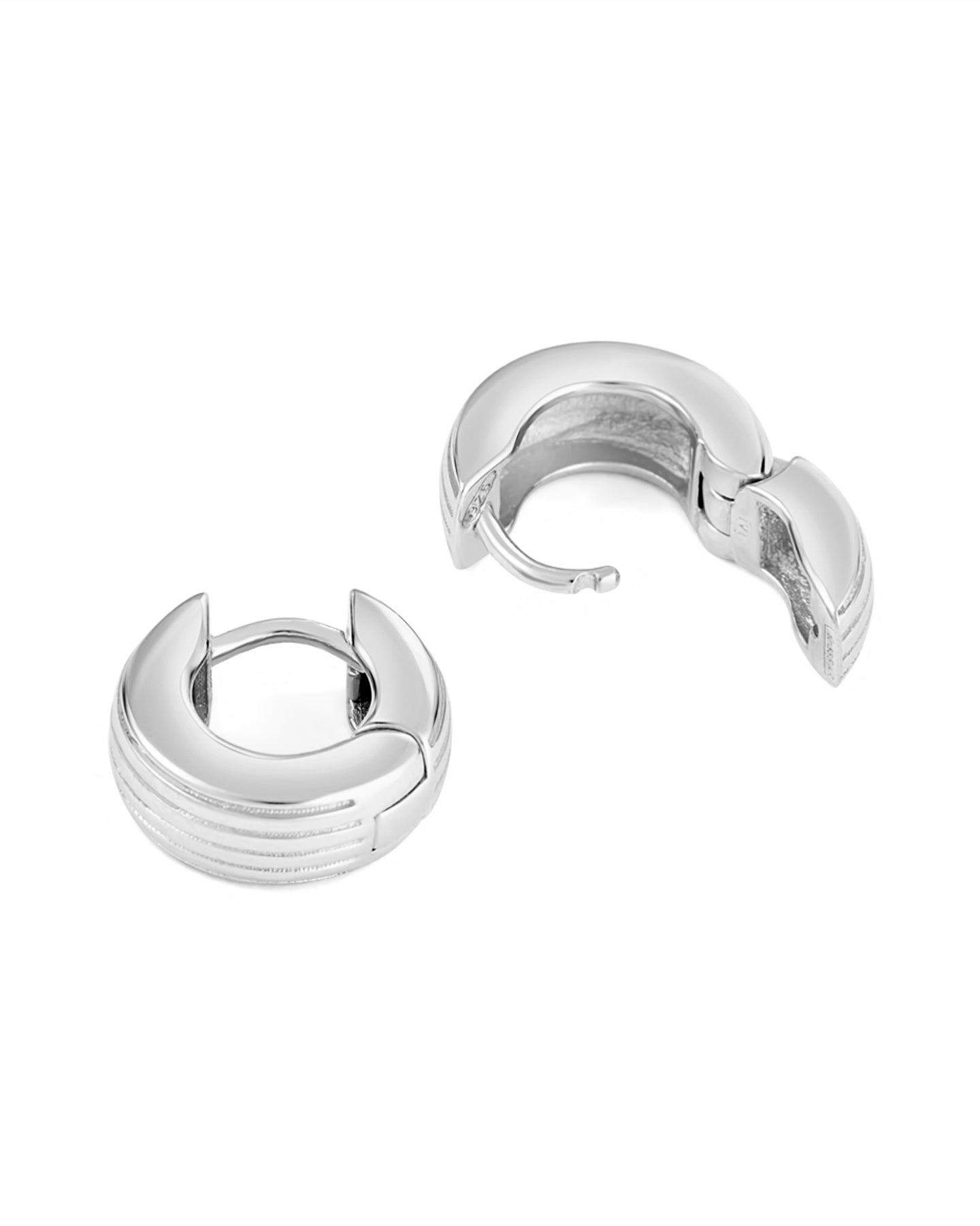 A pair of rhodium-plated round huggies earrings with a slim curved silhouette and engraved detailing on a white background.