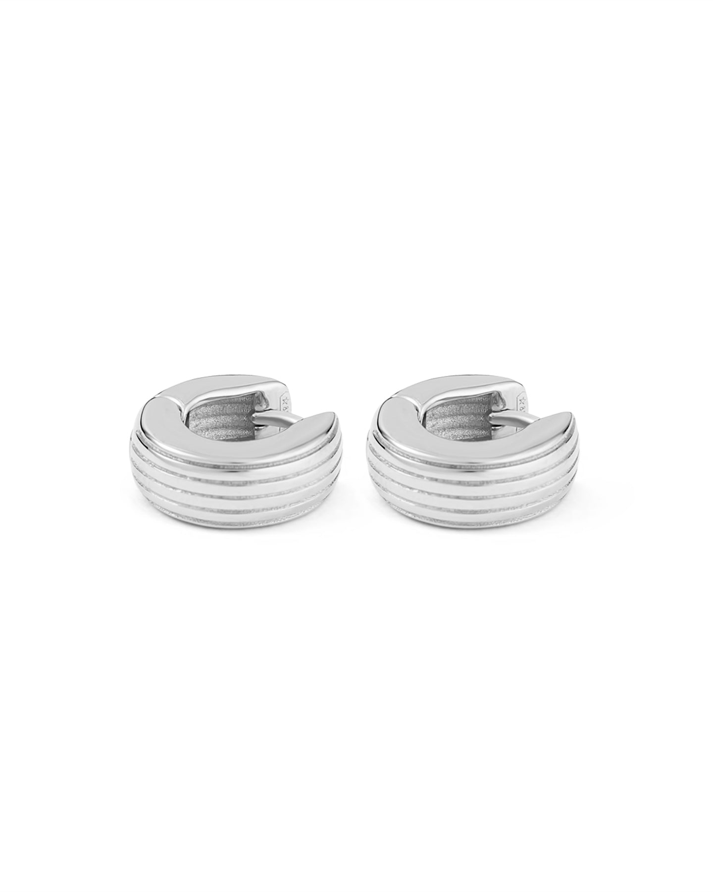 A pair of rhodium-plated round huggies earrings with a slim curved silhouette and engraved detailing on a white background.