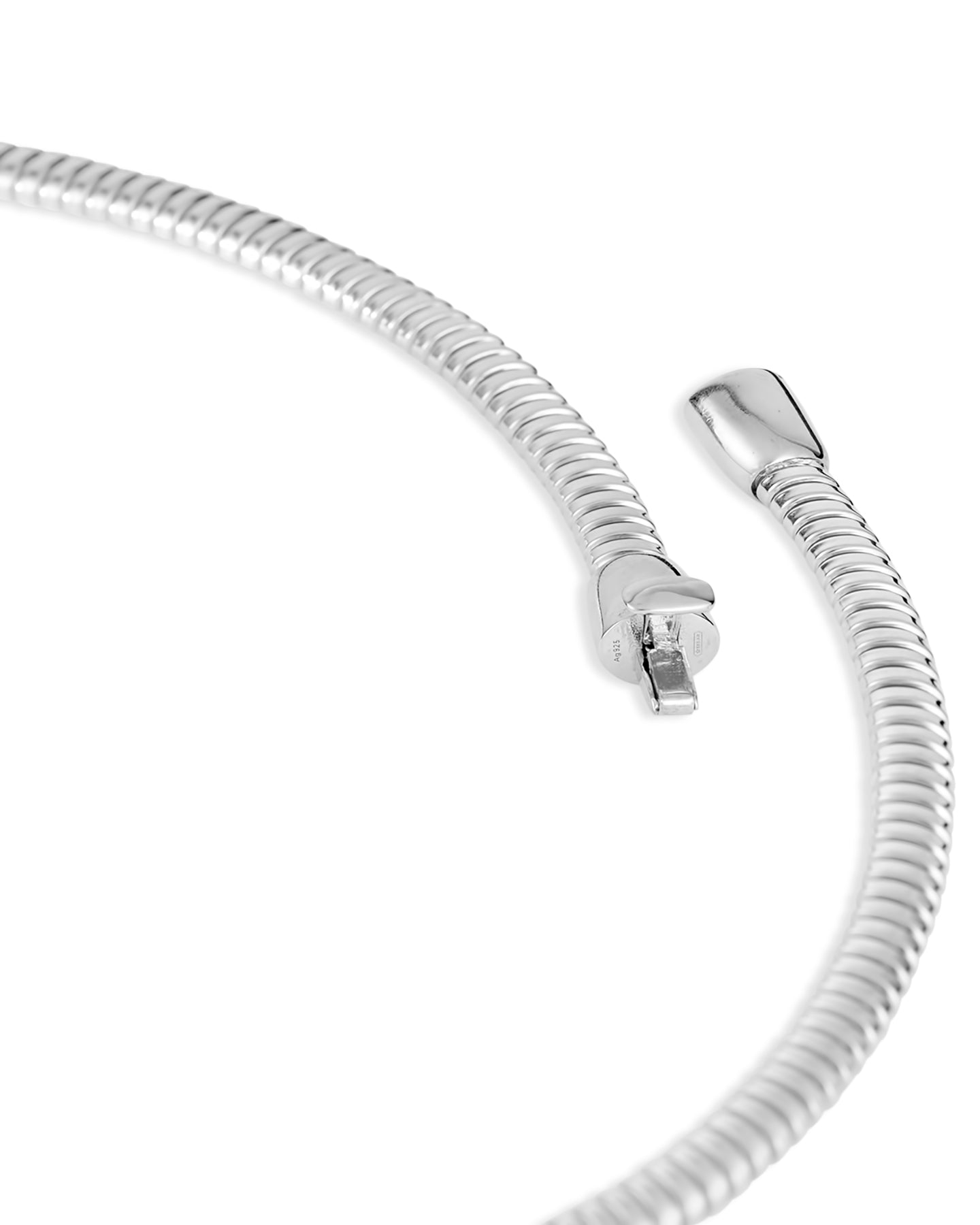 A close up of a rhodium-plated tubogas necklace with a flexible ribbed design and concealed clasp on a white background.