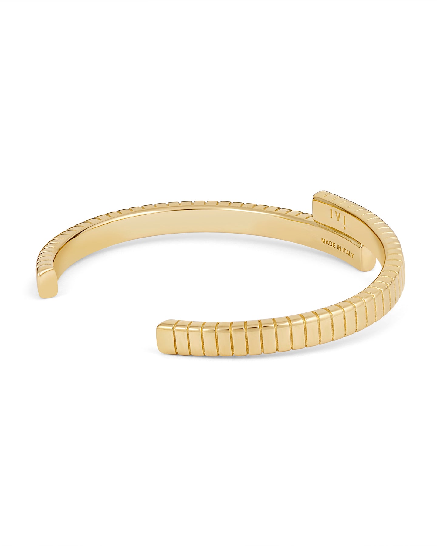 A gold-plated cuff bracelet with a twisted design and linear engravings on a white background.