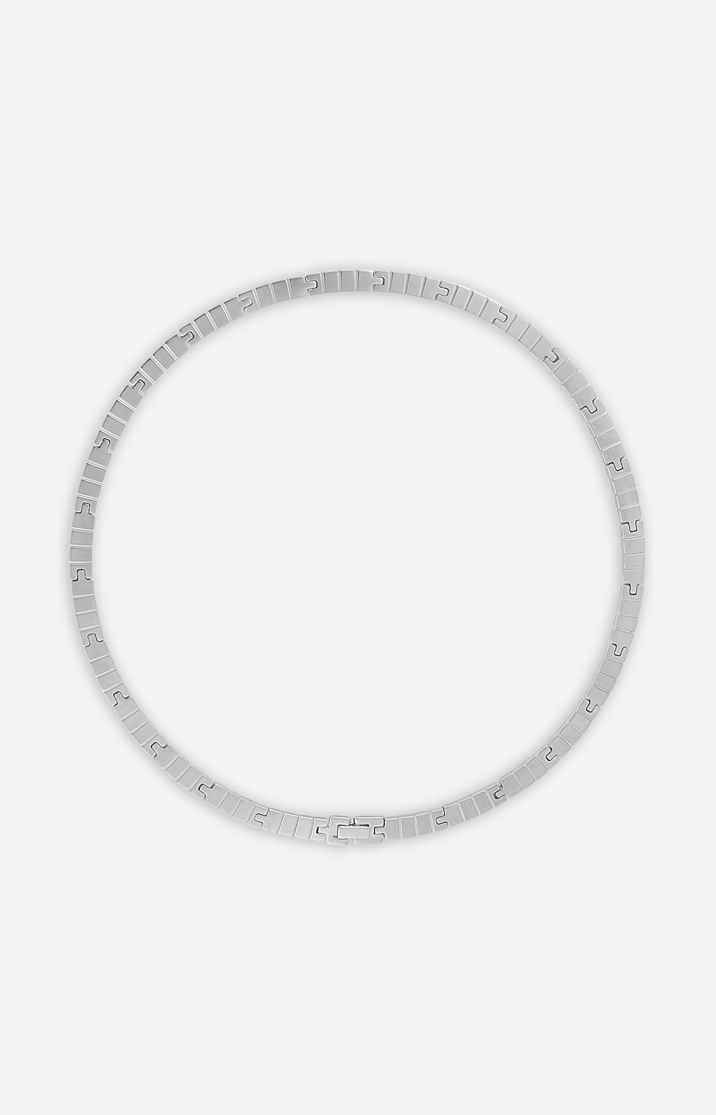 Silver necklace on a light gray background