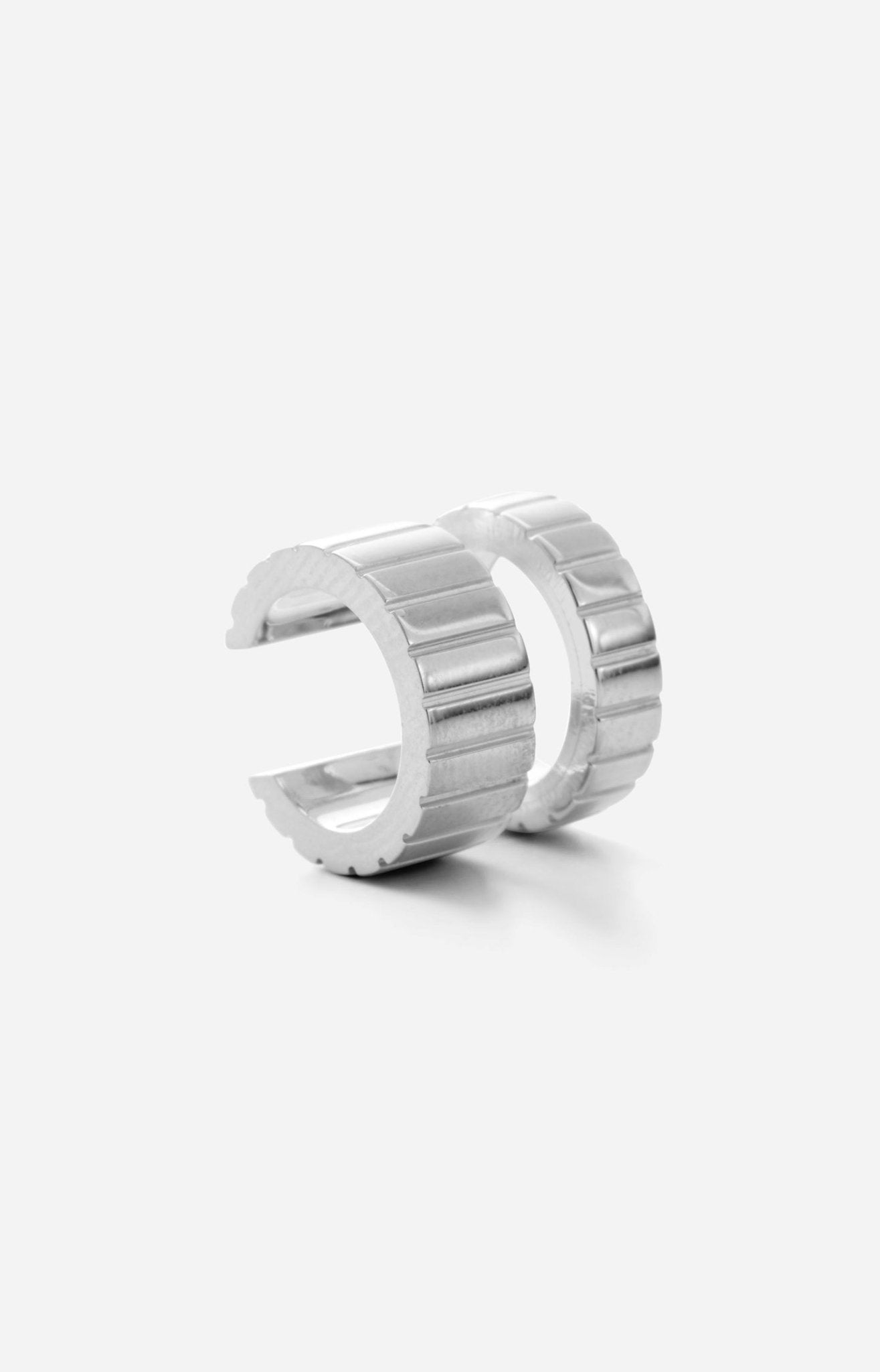 A rhodium-plated silver earcuff with a cutout center design, featuring meticulous engravings.