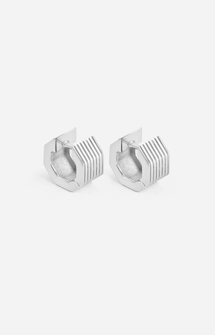 A pair of rhodium-plated wide octagon huggie earrings with a signature angular silhouette, designed to comfortably hug the lobe.