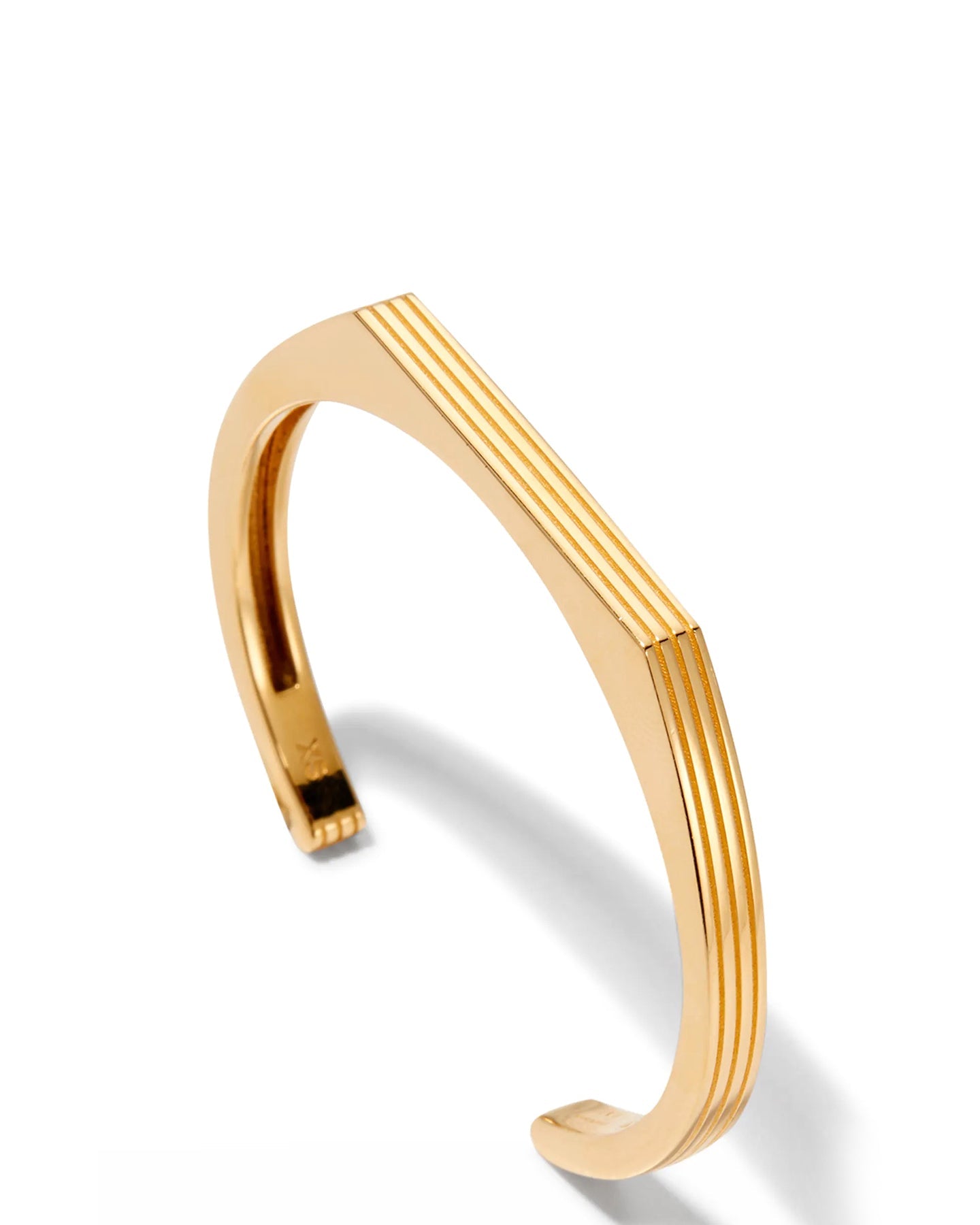 A gold-plated cuff bracelet with a sleek, modern design displayed on a white background